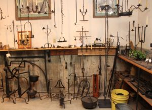 Inside Bob Alexander's Scrub Oak Forge. Features an array of ironworked pieces. Many candle stick holders among other items.