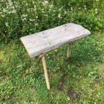 An almost finished wooden school, courtesy of James Price, master woodworker. Price has created a V shaped wooden based to the stool with 3 legs and hammered the wooden seat onto the frame using old square nails. This is a near finished product.