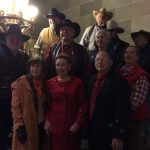 Jennie Cummings, in red, poses with First Lady Georganne Nixon and members of the Missouri Cowboy Poets Association at the Missouri Capitol after the 2016 Missouri Arts Awards. Jennie, center, wears a red matching suit with red beading around the neckline.
