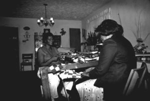 Photographed in black and white, Malverna Richardson faces another Black woman as the pair stitch quilts.