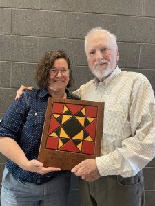 Folk Arts director present custom wood plaque to Howard W. Marshall.