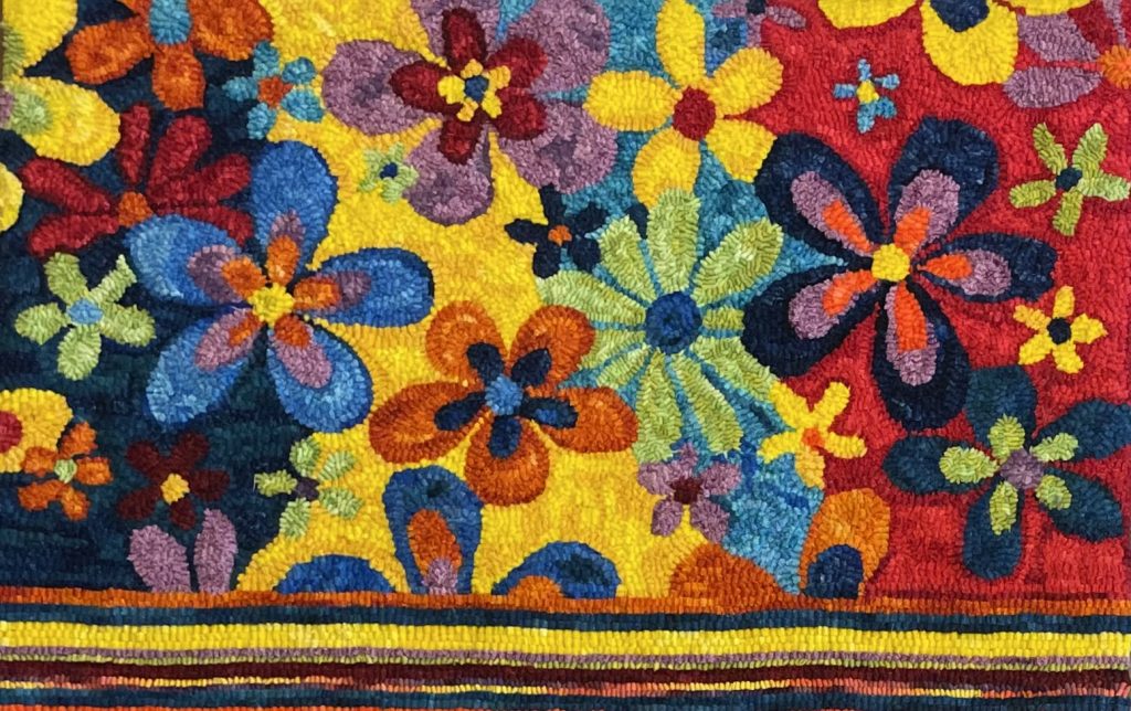Hooked rug featuring multicolored daisies