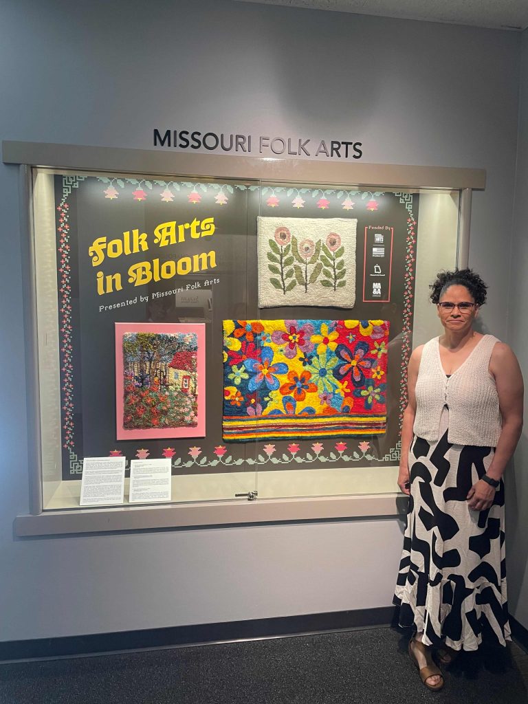Edholm stands beside Folk Arts in Bloom exhibit.